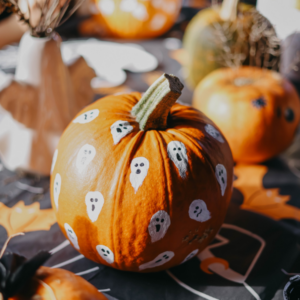 Small orange pumpkin with little white ghosts painted on
